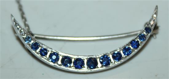 A white gold and sapphire crescent bar brooch, 1.5in.